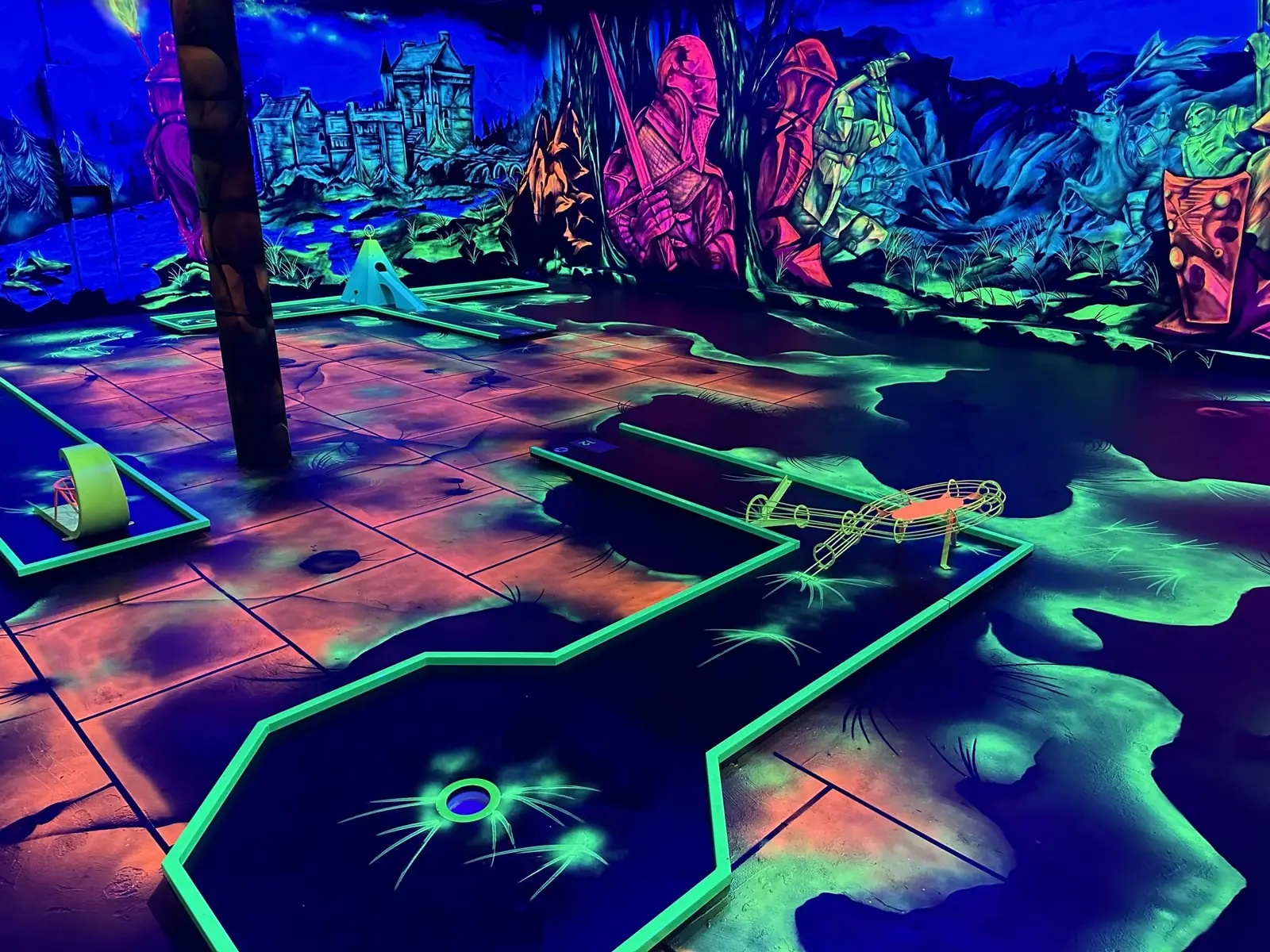 Schwarzlicht-Minigolfbahn mit leuchtender Kulisse
